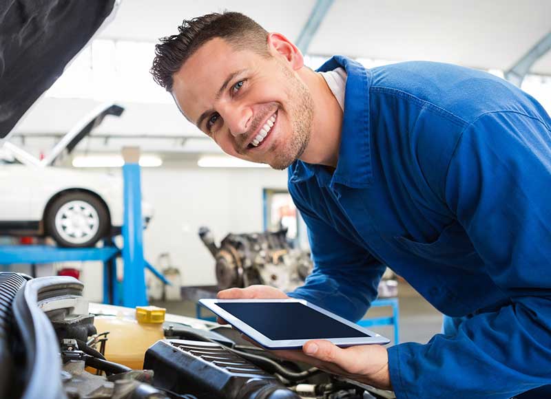 man holding IPad with open car bonet
